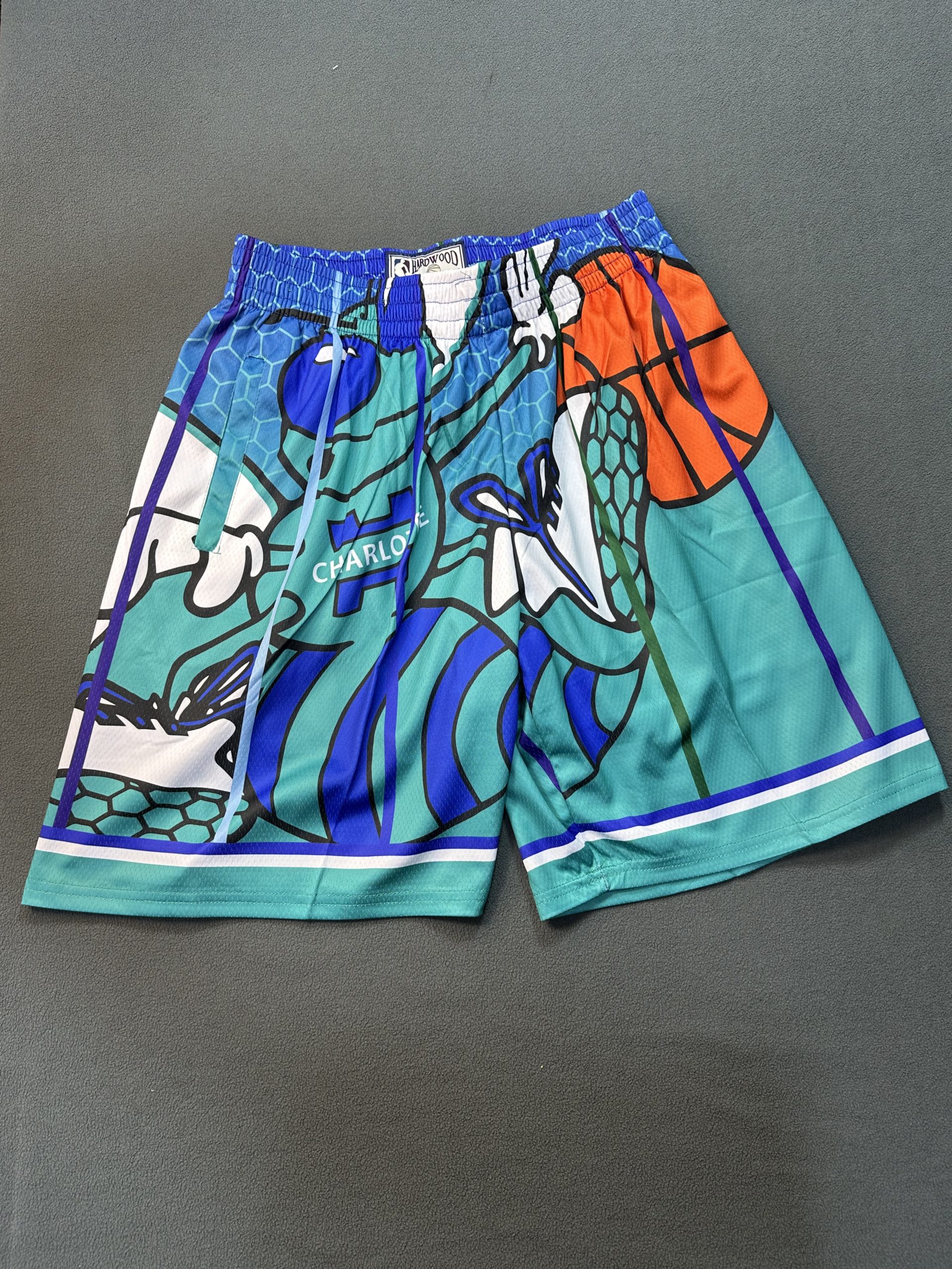 Short Charlotte Hornets Hardwood Celeste - Vista frontal Short NBA Charlotte Hornets color celeste marca Hardwood, vista frontal